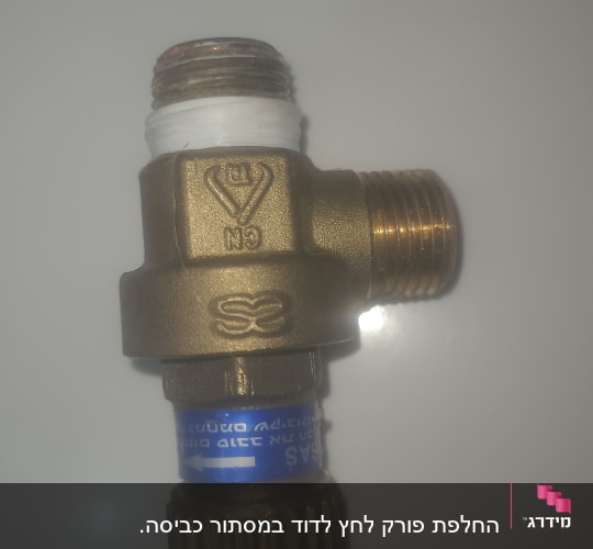 שסתום מתכת עם תווית כחולה על רקע לבן